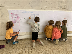 Eine Gruppe von Kindern, die auf einer weißen Tafel zeichnen